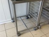 a pizza oven sitting on top of a cart in a kitchen