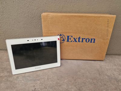 une tablette blanche posée sur une table, à côté d'une boîte