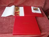une boîte rouge posée sur une table, avec une image à l'intérieur