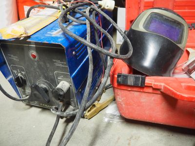 un casque de soudage et un poste à souder dans un garage