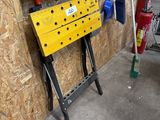 un établi jaune sur lequel sont posés des outils, dans un garage