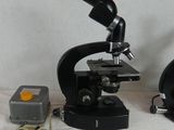 two microscopes that are next to each other on a table