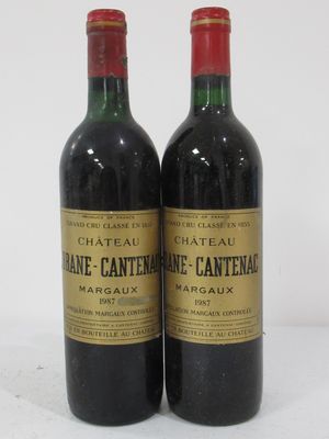 two bottles of wine sitting next to each other on a white surface