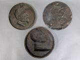three silver coins sitting next to each other on a white surface