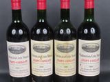 four bottles of wine are lined up on a table