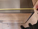 someone is measuring the height of a coffee table with a measuring tape