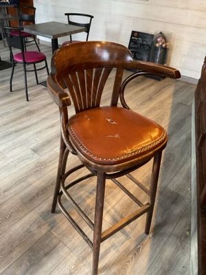 un tabouret de bar en bois avec une assise en cuir, dans une pièce