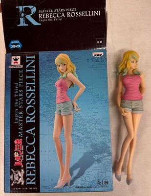 une poupée Barbie vêtue d'un haut rose et d'un short bleu, à côté d'une boîte de poupées Barbie