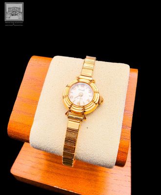 a watch that is sitting on top of a wooden stand