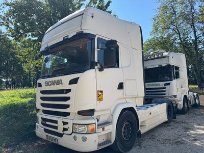 un camion blanc garé sur le bord de la route