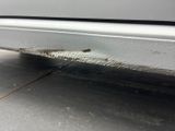 a close up of a car door with a rusted edge