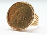 an image of a gold ring with a coin in the center
