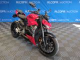une moto rouge garée sur un sol à damier