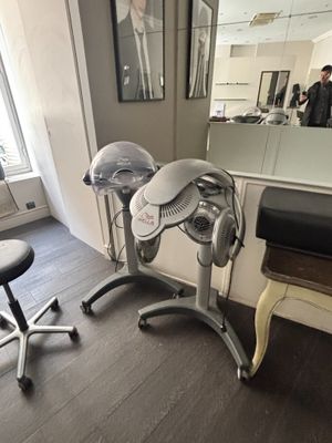 une photo d'un salon de coiffure avec un fauteuil et un miroir
