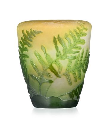 a green and yellow vase with a plant design on it