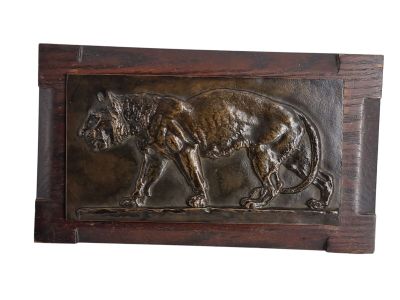 une image représentant une plaque métallique sur laquelle figure un lion, vu de dos