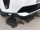 a close up of a car ' s front bumper with a lot of dirt on the ground