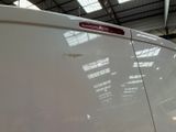 a close up of a white van with a red sticker on it