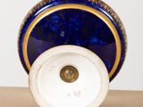 a blue vase with a gold rim sitting on a table
