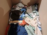 a box full of clothes that is sitting on the floor