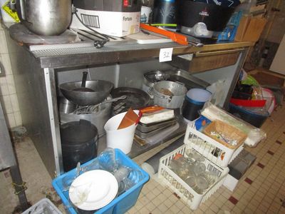 Les casseroles et les poêles sont rangées sur une étagère dans la cuisine.