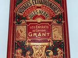 un vieux livre rouge avec des lettres dorées sur fond blanc