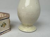 a small vase and a small box on a table