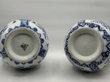 two blue and white vases with designs on them