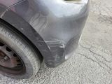 a close up of a car ' s front bumper with a denting on it