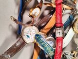 a pile of assorted watches and watches on a table