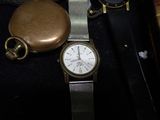 a watch and a pocket watch sitting in a case