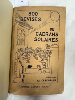 un vieux livre sur lequel figure l'image d'un chat assis sur le rebord d'une fenêtre