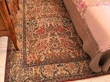 une photo d'une chambre avec un tapis au sol