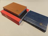 three books are stacked on top of each other on a table