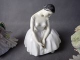 a figurine of a woman sitting on a table