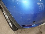 a close up of a blue car with a hole in the hood