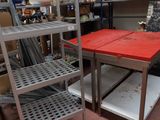 une table rouge au milieu d'une pièce remplie d'étagères
