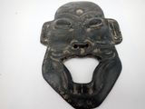 une image représentant un masque noir dont la bouche a la forme d'une tête de singe