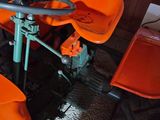 an orange lawn mower sitting on the floor next to a chair