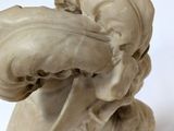 a white sculpture of a dog with a large mouth