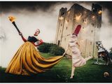 une image représentant deux femmes en costume, tenant des torches devant un château