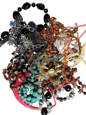 un tas de bracelets de toutes sortes posés sur une surface blanche