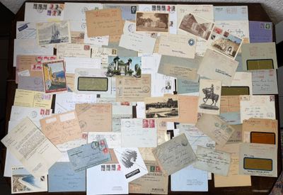 une table sur laquelle sont posées de nombreuses cartes postales anciennes et des enveloppes