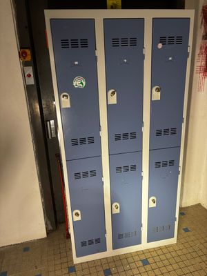 deux casiers bleus placés dans un couloir, à côté d'une porte