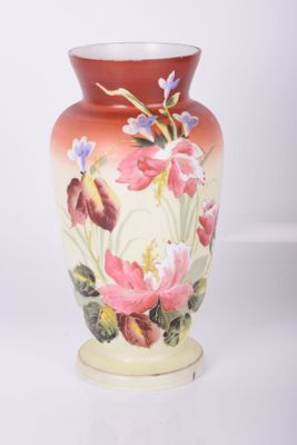 a vase with flowers painted on it sitting on a table