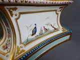 un vase sur lequel est peint un oiseau, posé sur une table