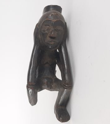 a wooden sculpture of a monkey hanging on a wall