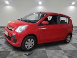 une voiture rouge est garée dans une pièce au sol en damier