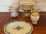 a wooden table with a bowl, vase, and plate on it