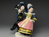 une figurine représentant un homme et une femme assis l'un sur l'autre